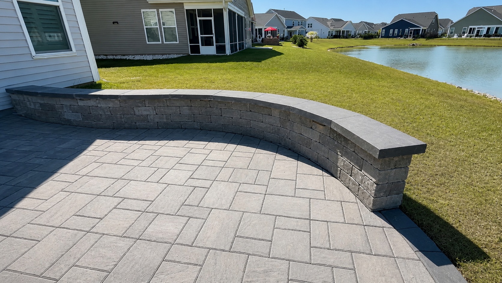 Curved paver seat wall with integrated ledge lighting installed by Precision Hardscape & Construction in coastal Carolina