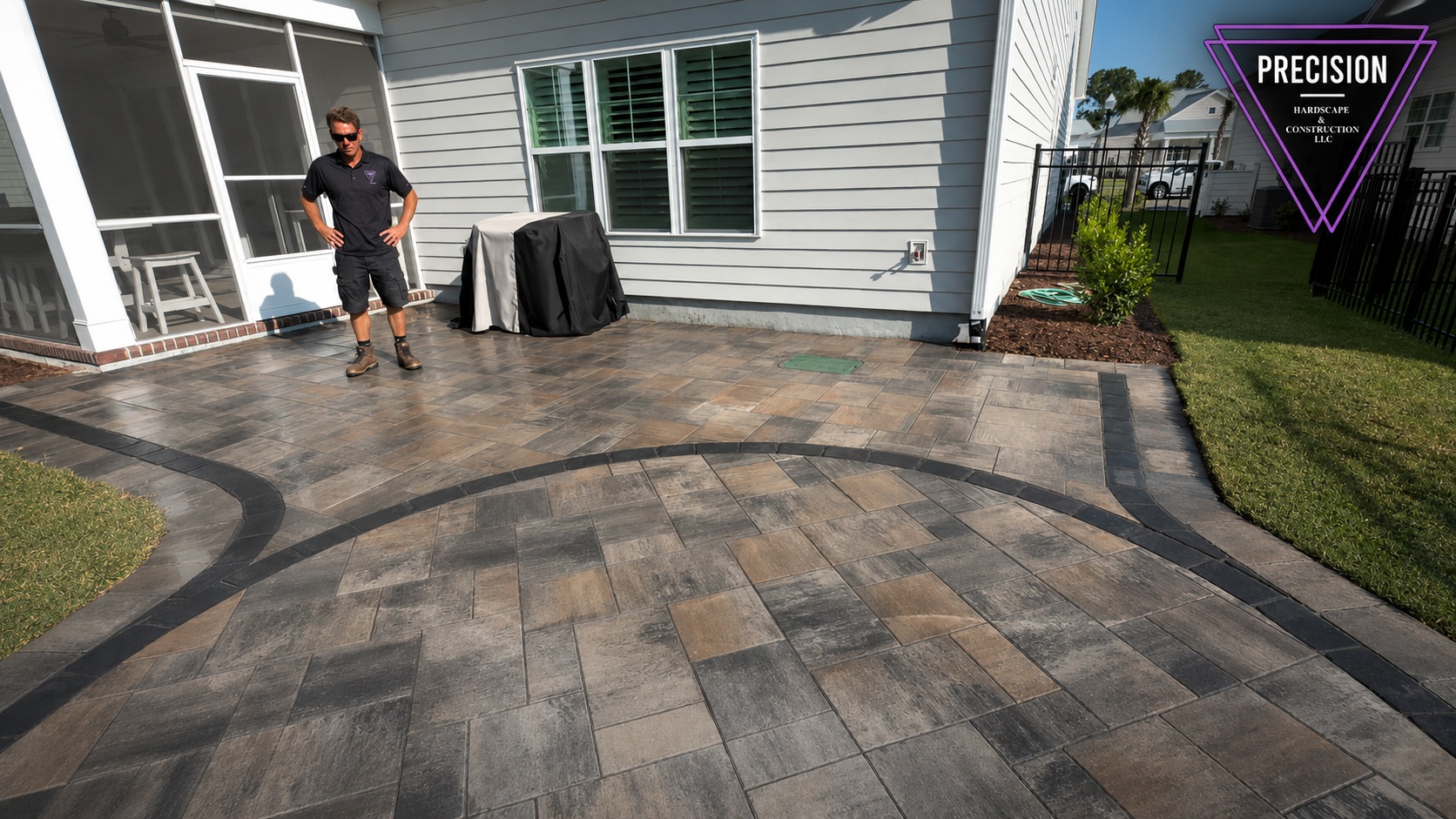 Belgard Slate paver patio with sweeping charcoal contrast border wrapping a coastal Carolina home — Precision Hardscape & Construction