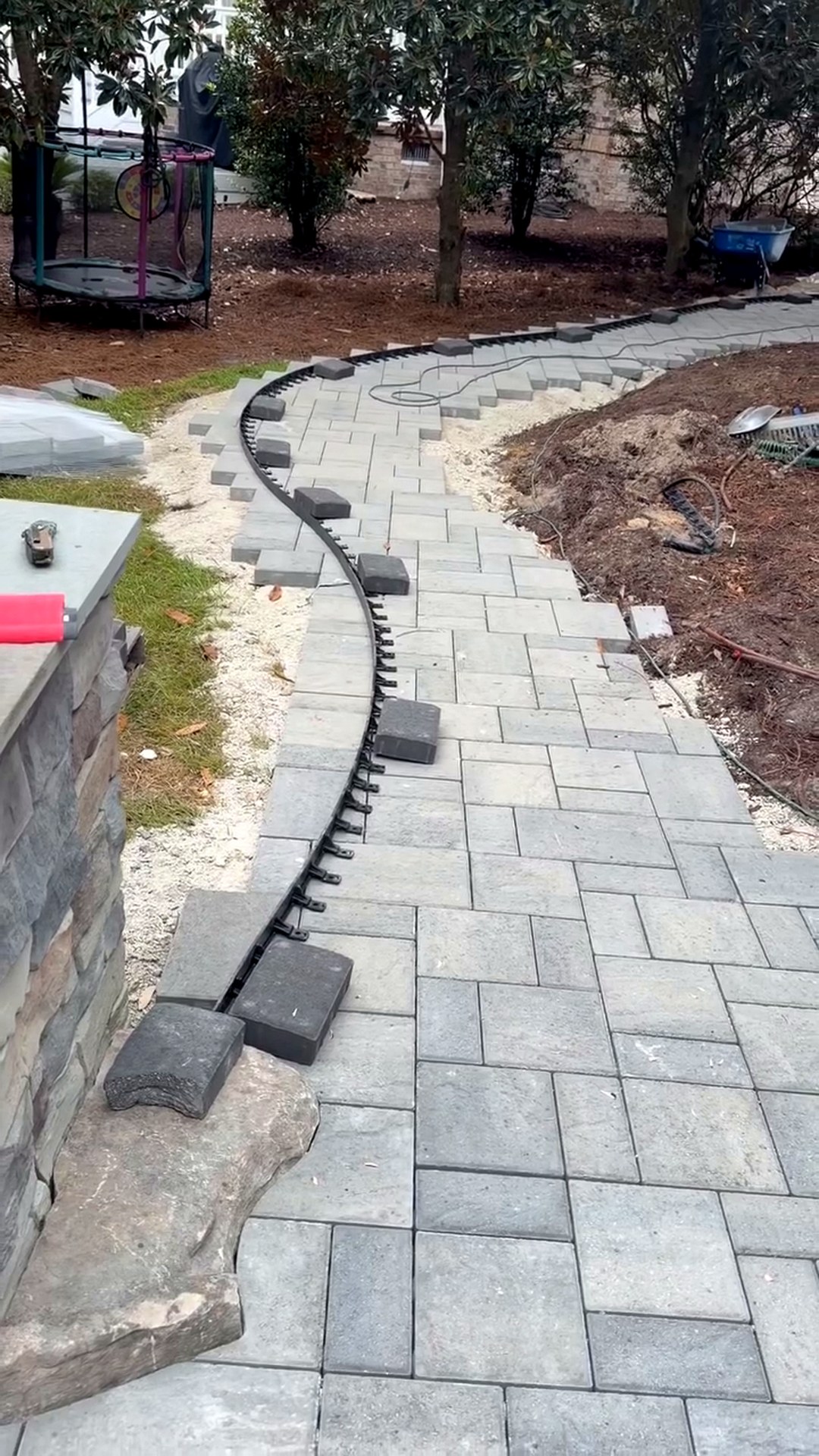 Paver walkway field laid long past the curve line, ready to be cut, on a coastal Carolina hardscape project